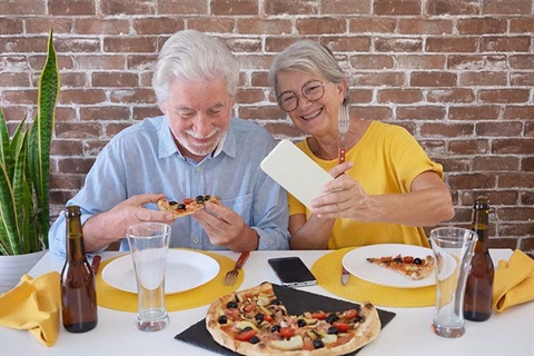 Happy senior couple eating pizza