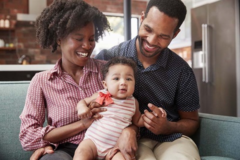 Family with baby daughter relaxing at home